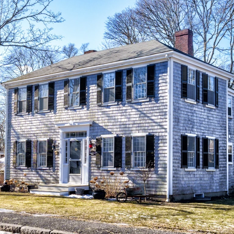 Front corner showing the two-story house in the sunlight